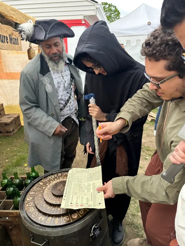 Pirate host guiding participants through the cipher wheel puzzle at X Treasure Hunt