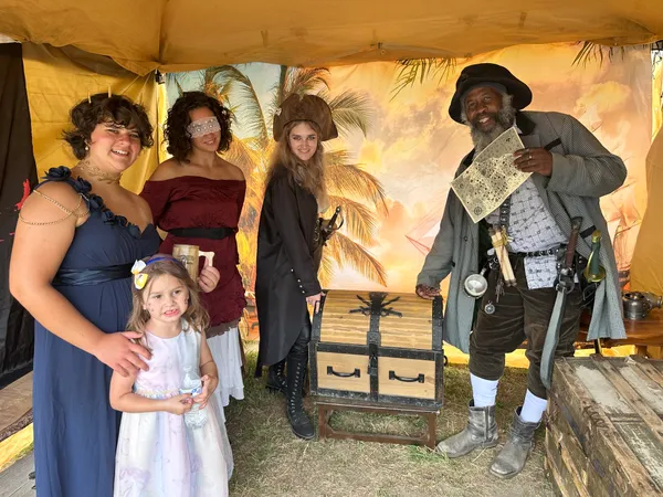 Family celebrating their quest completion beside the treasure chest