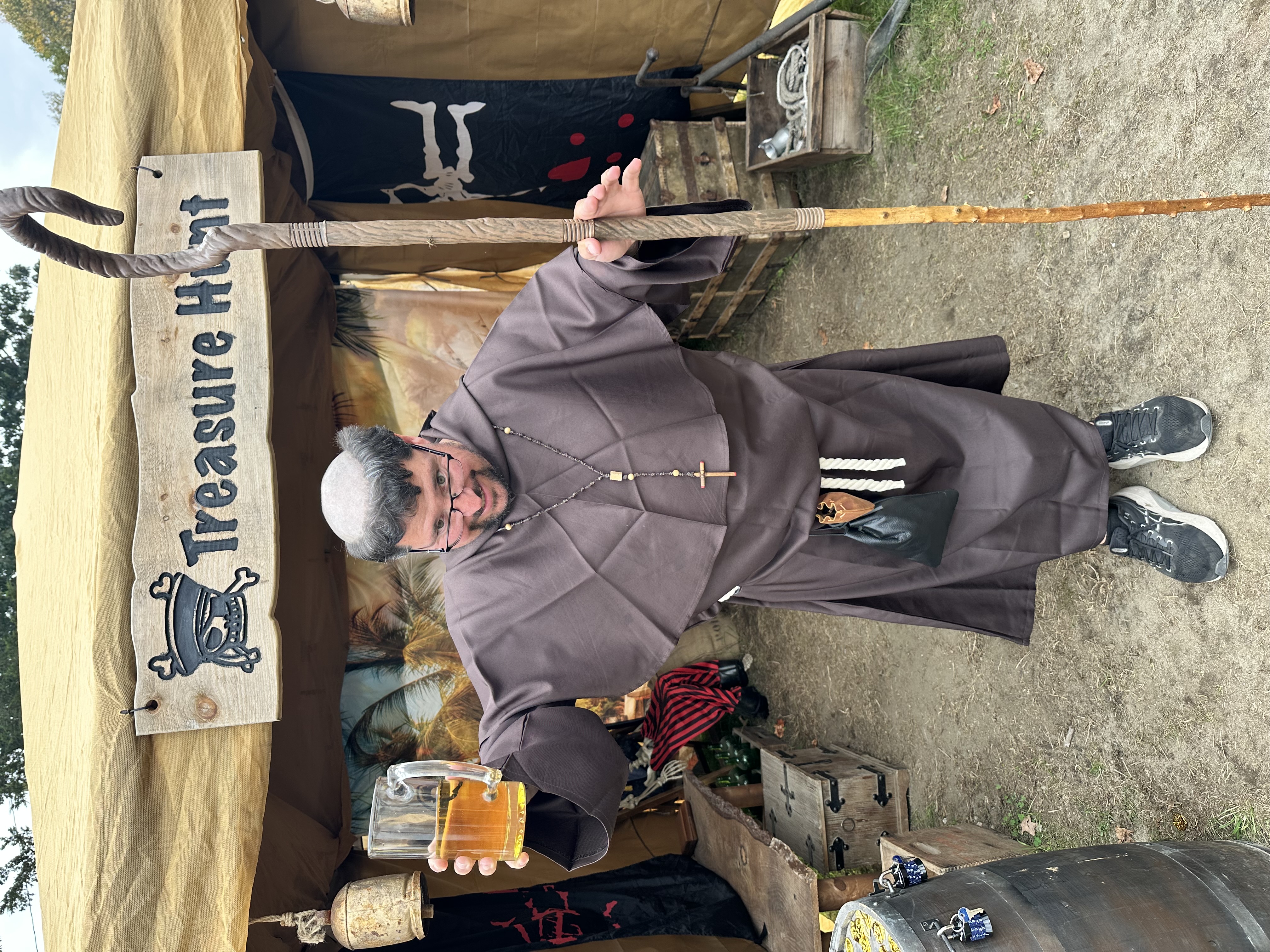 Medieval friar raising an ale mug at the X Treasure Hunt entrance