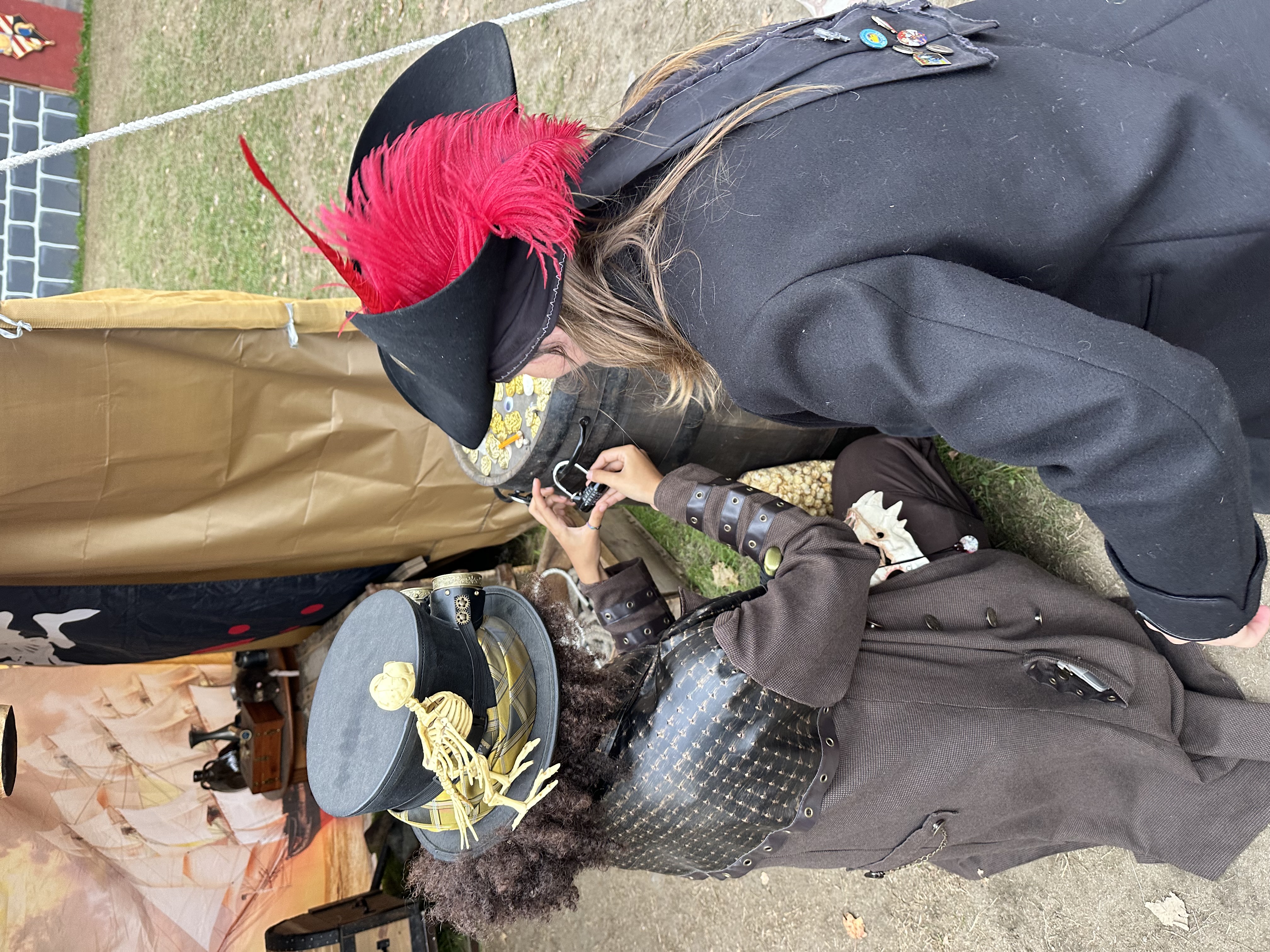 Steampunk and pirate adventurers working to open a combination lock on a treasure barrel