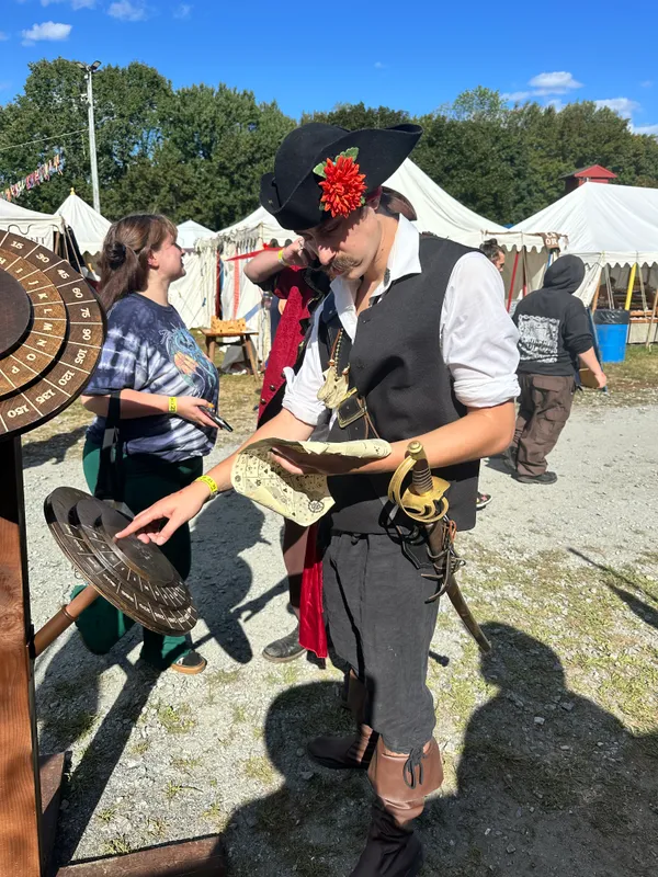 Adventurer in wide-brimmed hat studying a treasure map near the cipher wheels